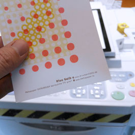 Frank Schulz Art vor der Risograph-Maschine mit einer Papierprobe von Metapaper in der Hand.