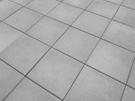 Sol extérieur carrelé, pose diagonale, avec des carreaux ciment. Pose sur une grande surface. Nuance aspect béton gris pour une belle terrasse facile d'entretien.