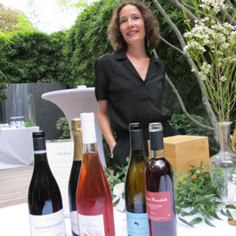 Sophie Roulé avec bouteilles de vins dans le jardin de l'hôtel particulier du 6 Mandel