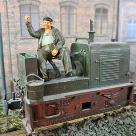 Lokführerfigur sitzend