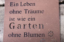 Metallschild im Rost-Look mit der Aufschrift: "Ein Leben ohne Träume ist wie ein Garten ohne Blumen"