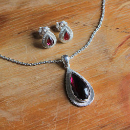 Parure composta da una collana con ciondolo e da un paio di orecchini a lobo con incastonati dei magnifici granati cabochon