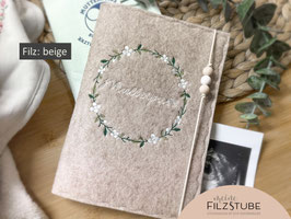 Mutterpasshülle Filz Blumenkranz Motiv erstes Foto: Filz beige I Blumenkranz Tanne I Oliv I Weiß I "Mutterpass" weiß I Schriftart Allura I Gummikordel creme I Perlen: Natur/weiß/Natur