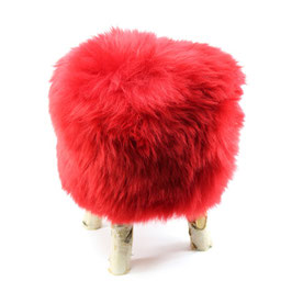 Tabouret scandinave fabriqué avec 4 pieds en bois de bouleau naturel brut et son assise en peau de mouton teintée rouge ferrari