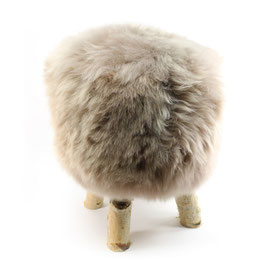 Tabouret scandinave fabriqué avec 4 pieds en bois de bouleau naturel brut et son assise en peau de mouton teintée grège