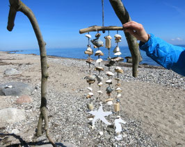 Windspiele aus weißen Muscheln mit braunem Treibholz