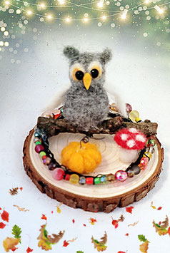 Kleine Eule auf Holzscheibe