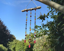 Windspiel und Sonnenfänger mit bunten Glasperlen am Treibholz