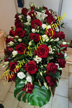 Mezzo cofano con rose rosse, lisianthus bianco, ruscus e foglie di monstera