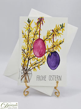 Forsythienzweige mit bunten Ostereiern