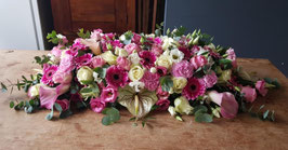 Langwerpig Rouwarrangement met roze en witte rozen, anthurium, anjers en eustoma en gerbera