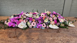 Langwerpig rouwarrangement met orchideeën en anthuriums in roze en witte tinten 120 cm.