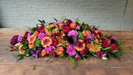 Langwerpig creatie van 80 cm. In oranje, rode, roze en gele tinten