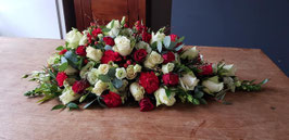 Druppel Arrangement met witte rozen, rode rozen, rode anjers, witte eustoma en eucaluptus en grassoorten