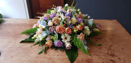 Een Rouwarrangement in de vorm van een biedermeier in pasteltinten  80 cm.
