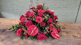 Rond rouwarrangement in rode tinten met anthuriums, gerbera en rode rozen 60 cm.
