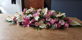 Langwerpig Rouwarrangement met anthuriums, lelies, rozen en gerbera’s, lengte 110 cm.