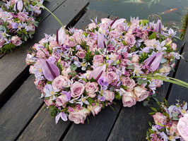 Dubbel open hart opgemaakt met anthuriums, rozen, clematis in lila tinten