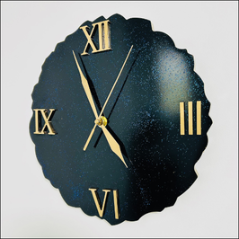 Horloge murale noire avec des paillettes bleutées et des chiffres romains dorés
