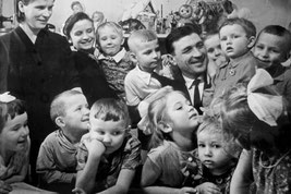 Nikolai Massolow unter vielen kleinen Kindern. Er rettete als Soldat der Sowjetarmee am 30.4.1945 in Berlin unter Lebensgefahr ein 3-jähriges deutsches Mädchen. Er wurde Vorbild für die Statue Sowjet. Ehrenmal Treptow. Quelle Foto: Russ. Botschaft Berlin