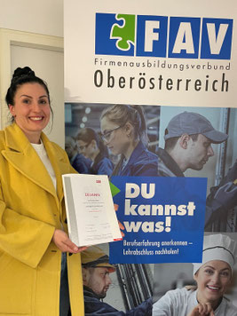 Tamar Karumidze mit Diplom im Einzelhandel vor dem "Du kannst was"-Rollup