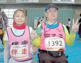 フルマラソン24㌔にゴールした桑村昌和さんと伴走者の仲里初子さん=24日、石垣市中央運動公園屋内練習場
