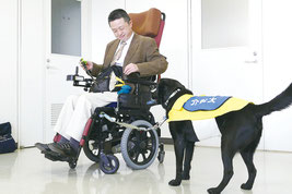 デモンストレーションを行う新開さんと介助犬「オメガ」=17日午前、八重山合同庁舎
