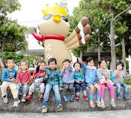 ぱいーぐるのモニュメント除幕式が行われ、集まった子どもたち=7日午後、市役所玄関前ピロティ