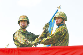 陸上自衛隊の小川清史西部方面総監(左)から隊旗を受け取る沿岸監視隊の塩満大吾隊長=28日午前、与那国町
