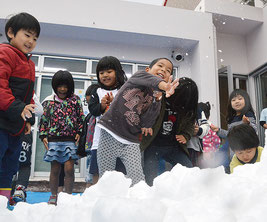 雪のプレゼントに大興奮の園児。雪合戦がスタートした=25日、みやら保育園
