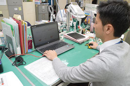 サーベイランスで感染症状況を確認する伊本剛主任=26日、八重山福祉保健所
