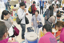 さんぴん茶やマンゴージュース、ちんすこうを楽しむ観光客ら=7日午後、南ぬ島石垣空港ターミナル