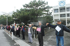 手をつないで市役所を包囲する自衛隊配備反対派の人たち(10日午後)