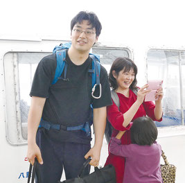黒島港に到着し、歓迎される吉山医師一家=18日午後、黒島港