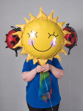 Person mit gelbem Sonnenballon vor dem Gesicht bei einem kreativen Influencer-Shooting im Fotostudio in Stuttgart.