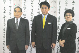 辞令交付後、中山市長、石垣教育長とともに記念撮影に臨む漢那副市長(左)=12日午後、市役所