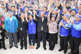 3期目当選確実を受け、バンザイ三唱する島袋氏(前列中央)と支持者ら=23日午後11時ごろ