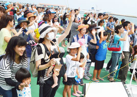 「いぜな」甲板で機動救難士に手を振る参加者=18日、石垣港