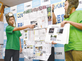 壁新聞を紹介する竹内君(右)と石田君=21日、竹富町役場