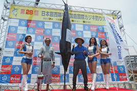 最終日トップ、150㌔のクロカワを釣り上げた上間徳三郎さん(左から2人目)=9日午後、久部良漁港
