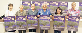 完成したポスターを持つ実行委員ら=24日夜、県総合福祉センター(那覇市)
