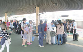 沖に避難したフェリーを降り、荷物を受け取る人たち(手前)と乗船を待つ列(奥)=20日午後、石垣港離島ターミナル