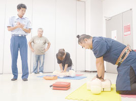 救命士(左)に教わりながら心肺蘇生の実習を行う参加者ら=11日午後、市総合体育館