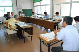 市議会の新庁舎建設調査特別委員会で大城室長(右)に質問する市議たち=21日午前、市役所