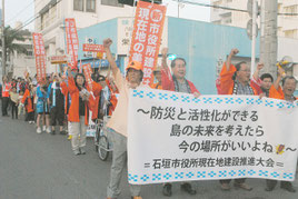 市役所の現地建て替えを求めてデモ行進する人たち=10日午後、美崎町