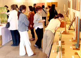 熱心に八重山上布を観賞する来場者ら=17日、市民会館展示ホール
