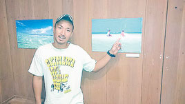 自身の作品の前でコンドイ浜の魅力を語る上勢頭輝さん=3日、竹富島ゆがふ館内テードゥンギャラリー