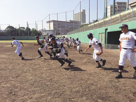 守備練習を中心に汗を流す八重高ナイン=23日午後、鹿児島市鴻池公園野球場