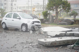 5階建てホテルの建物から落下した外壁とフロント部分が大破した車両=7日午後、石垣市八島町