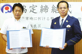 大規模災害における代替施設協定調印した(左から)中山市長、仲村署長=18日午後、市役所